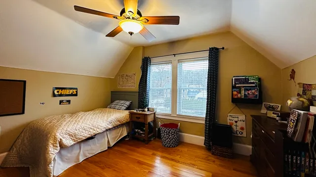 a bedroom with a bed dresser and a large window