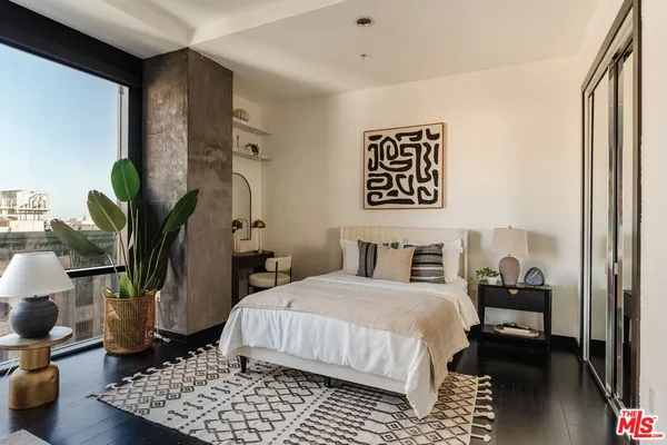 a bedroom with a bed and a lamp on dresser