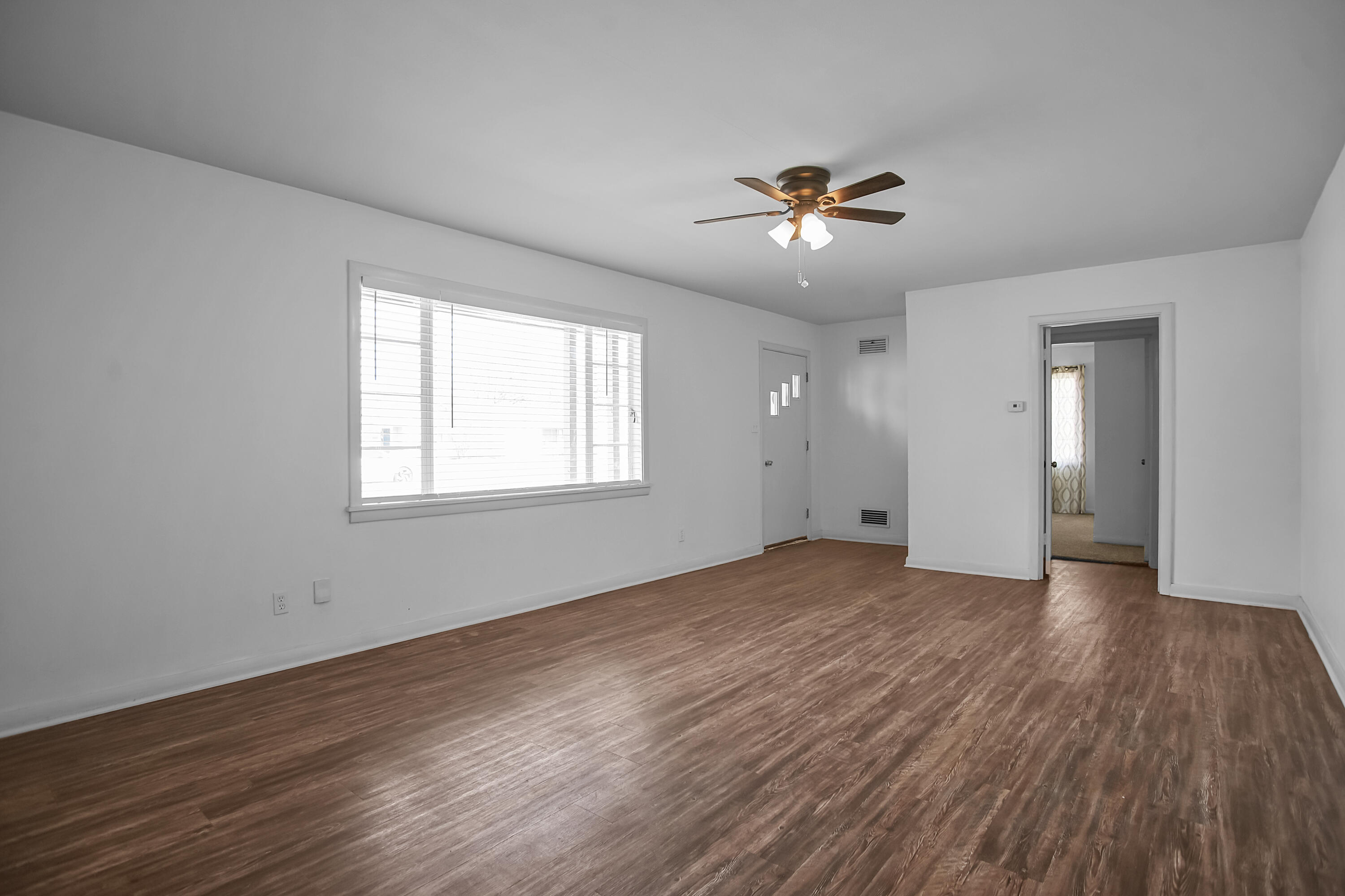 4309 31st Street Lubbock, TX 79410 - Photo 22 of 30 a view of an empty room with wooden floor and a window