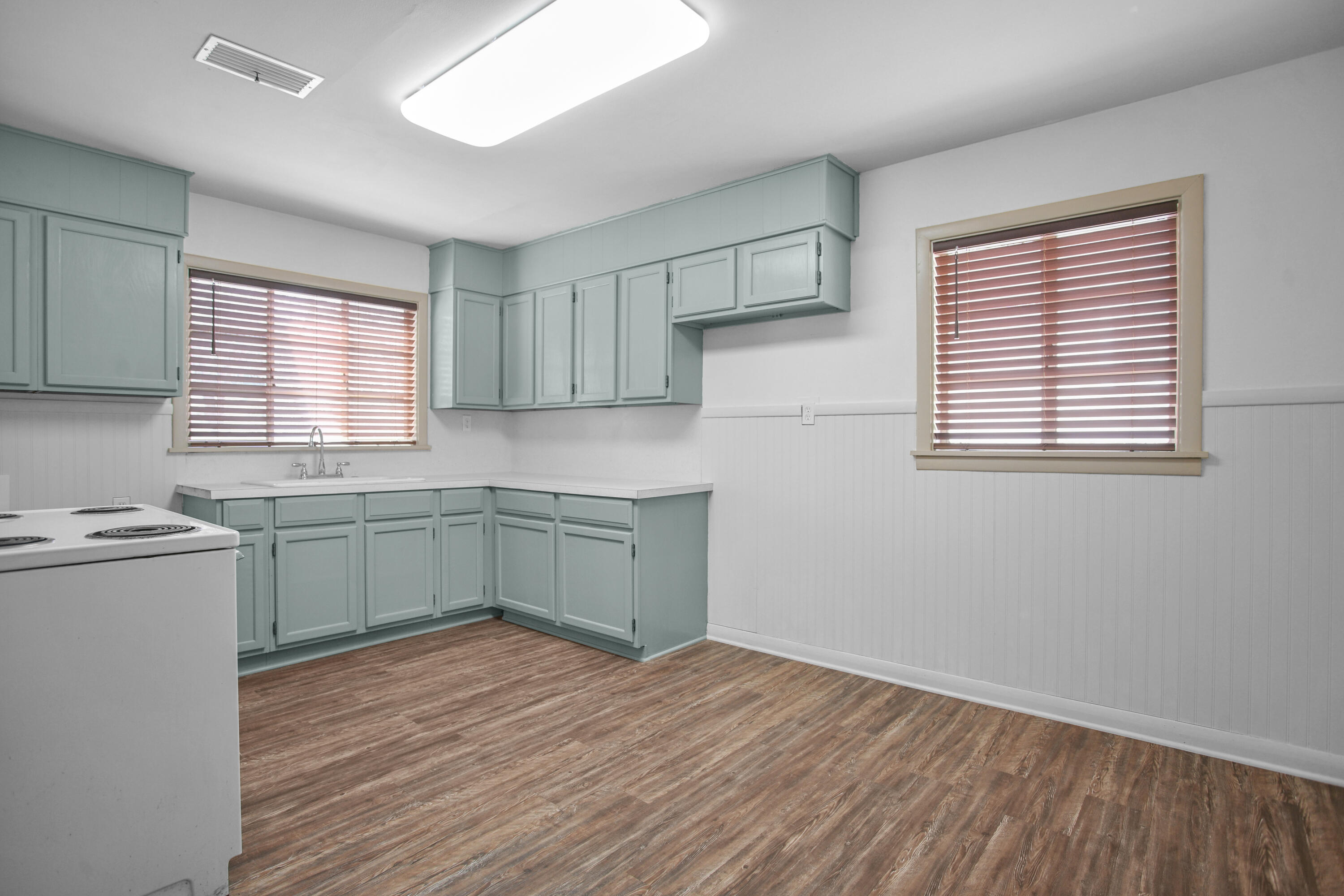 4309 31st Street Lubbock, TX 79410 - Photo 24 of 30 a kitchen with a sink cabinets wooden floor and a window
