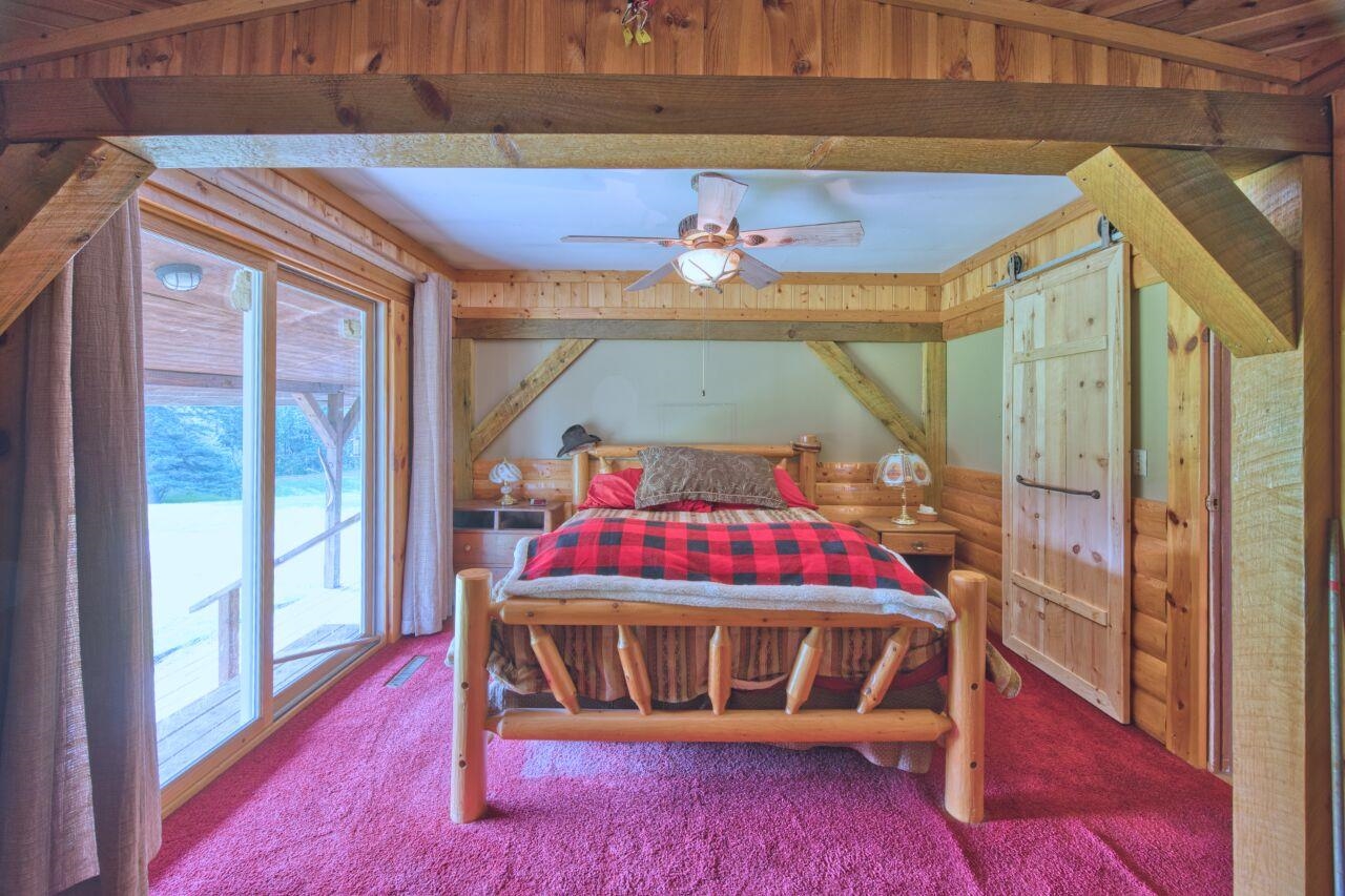 7349 Lax Road Embarrass, MN 55732 - Photo 11 of 36 Carpeted bedroom with access to exterior and beam ceiling