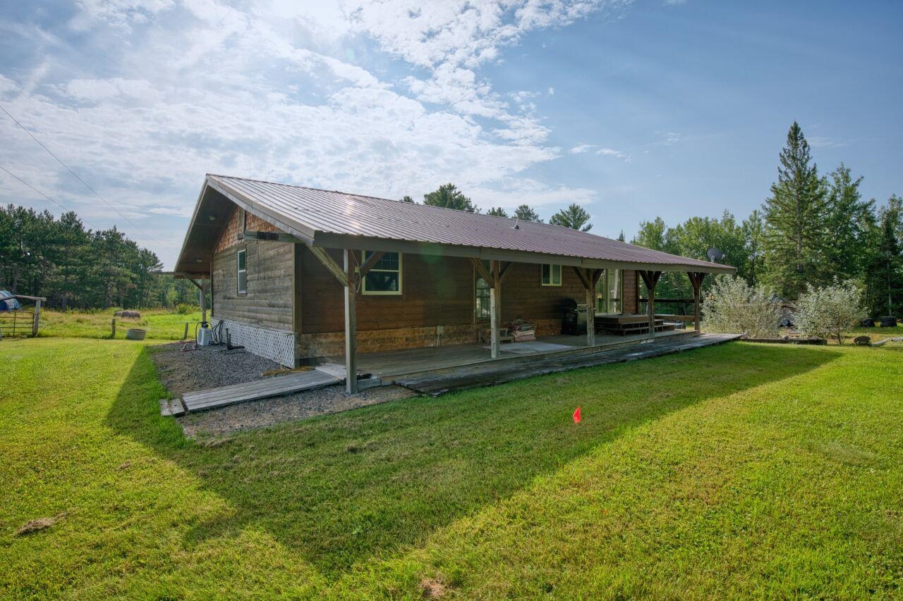 7349 Lax Road Embarrass, MN 55732 - Photo 23 of 36 Back of house featuring a yard, a metal roof, and a wooden deck