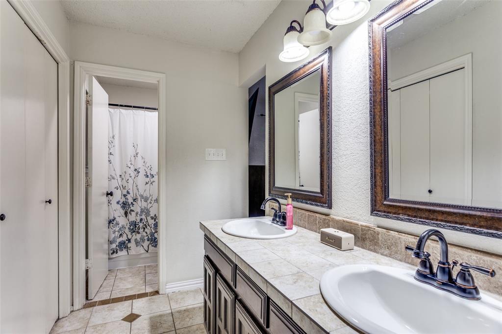 6304 Old Mill Circle Watauga, TX 76148 - Photo 18 of 25 a bathroom with a granite countertop sink and a mirror