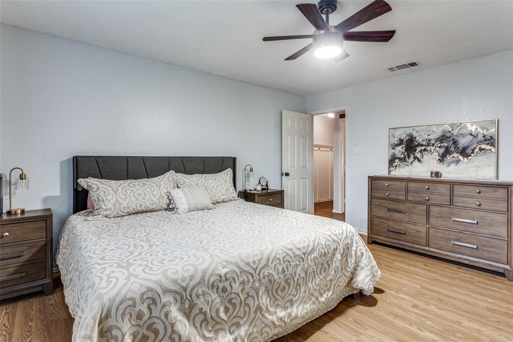 6304 Old Mill Circle Watauga, TX 76148 - Photo 19 of 25 a bedroom with a bed and a chandelier