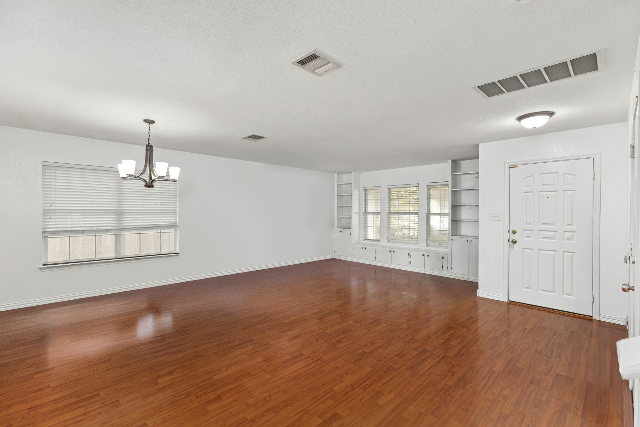 144 Vicksburg Loop Elgin, TX 78621 - Photo 18 of 23 a view of an empty room with wooden floor and a window