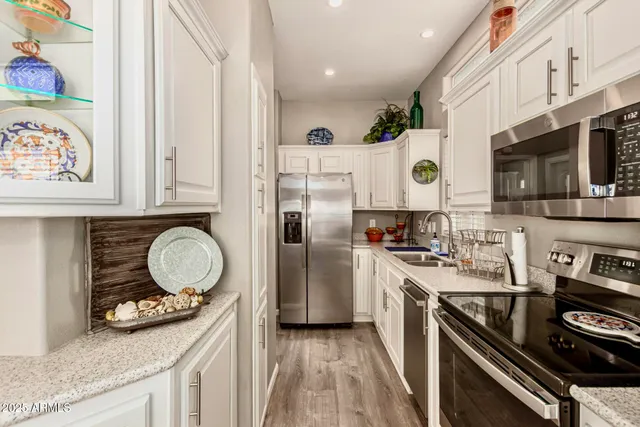 a kitchen with appliances a sink and cabinets