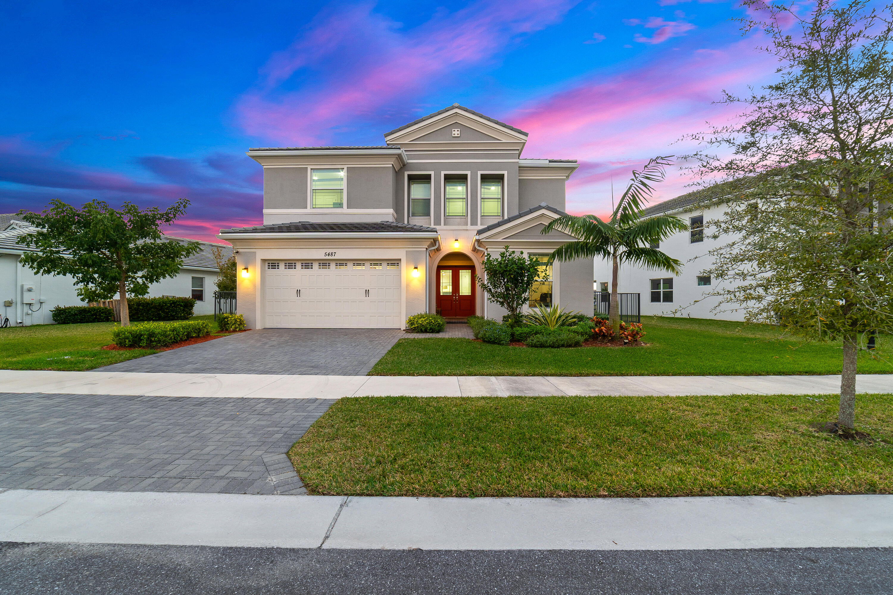 a front view of a house with a yard and garage