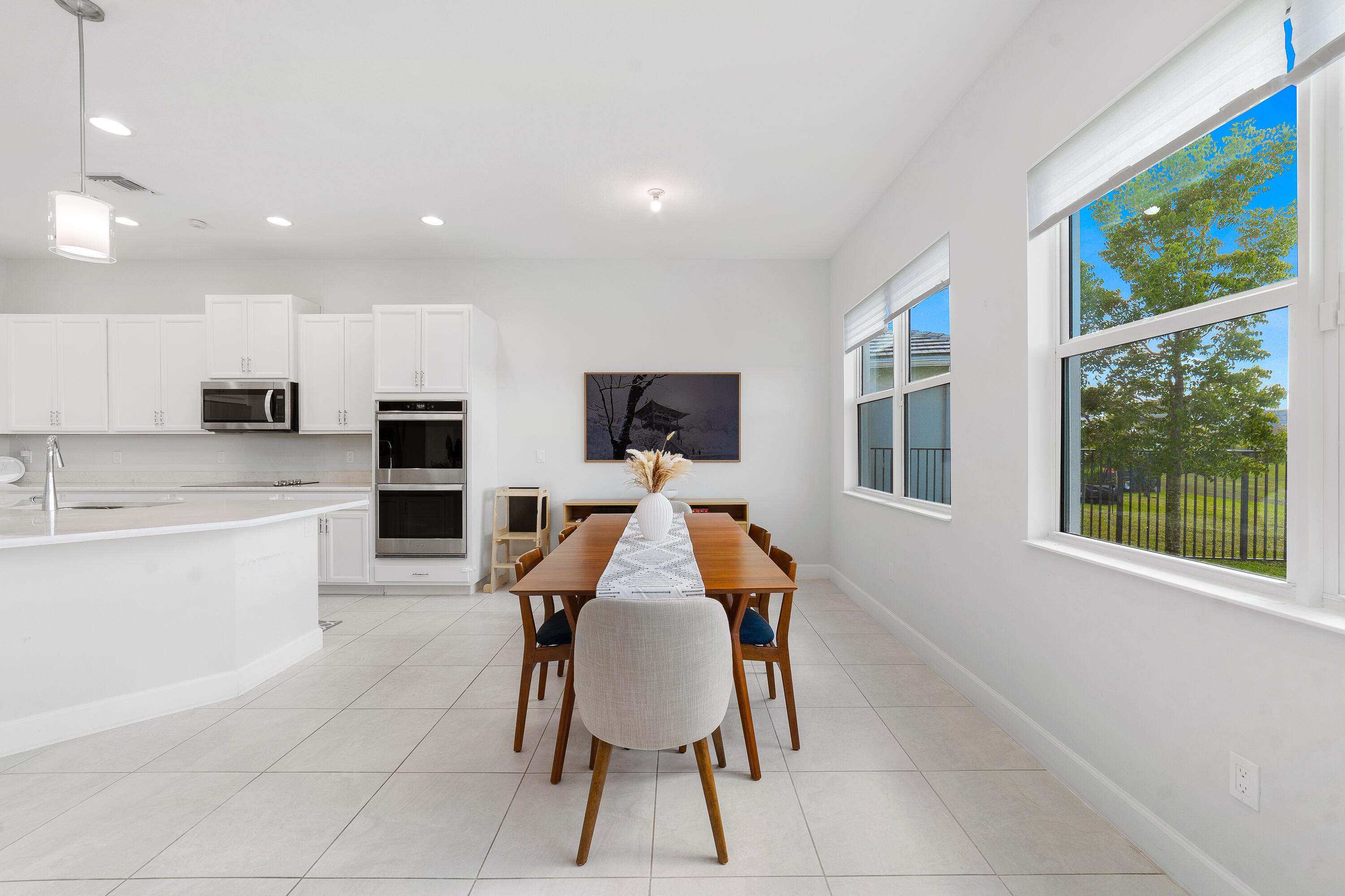 5487 Macoon Way Loxahatchee, FL 33470 - Photo 12 of 66 a dining room with kitchen island furniture a large window and stainless steel appliances