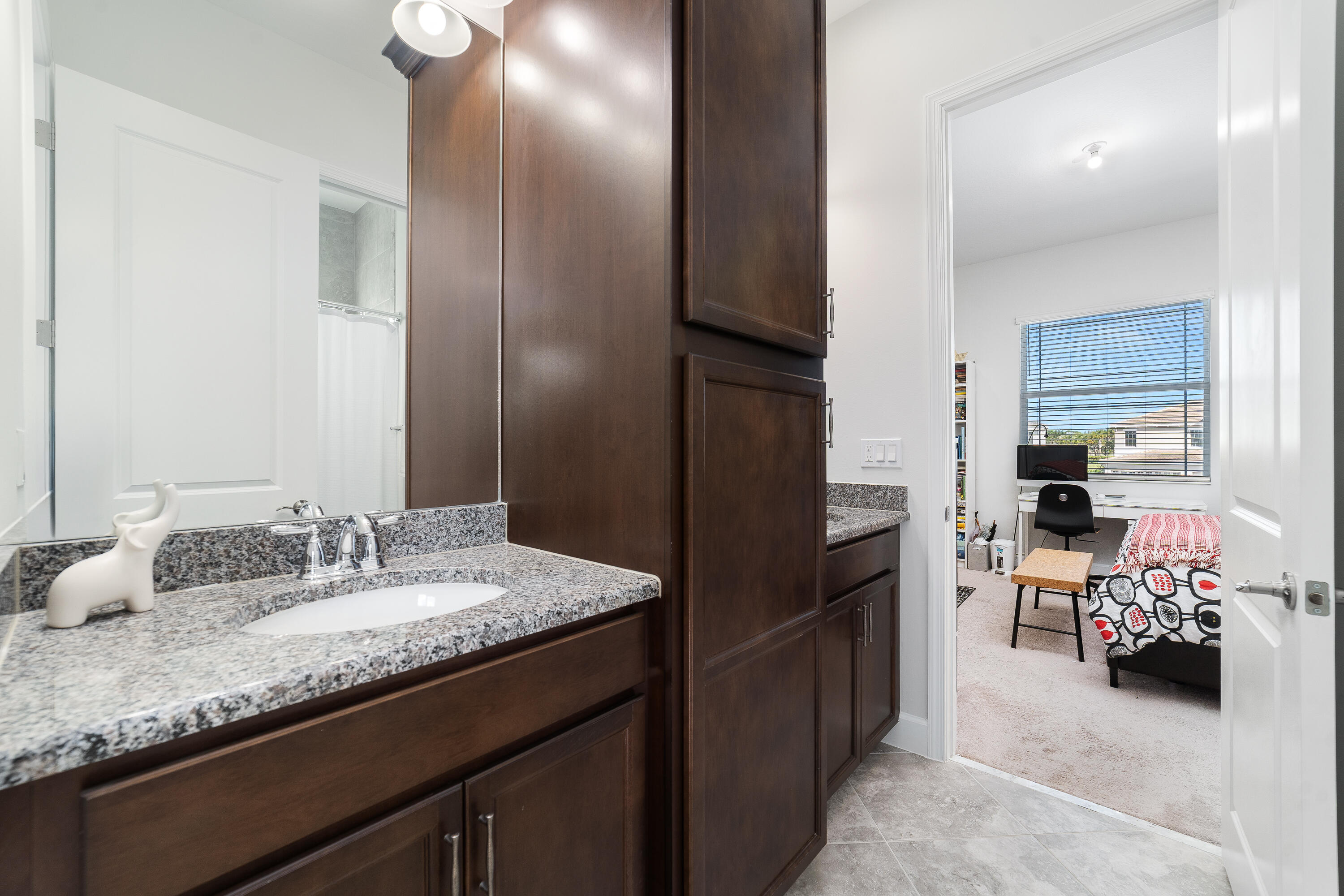 5487 Macoon Way Loxahatchee, FL 33470 - Photo 28 of 66 a en suite bathroom with a granite countertop sink and a mirror