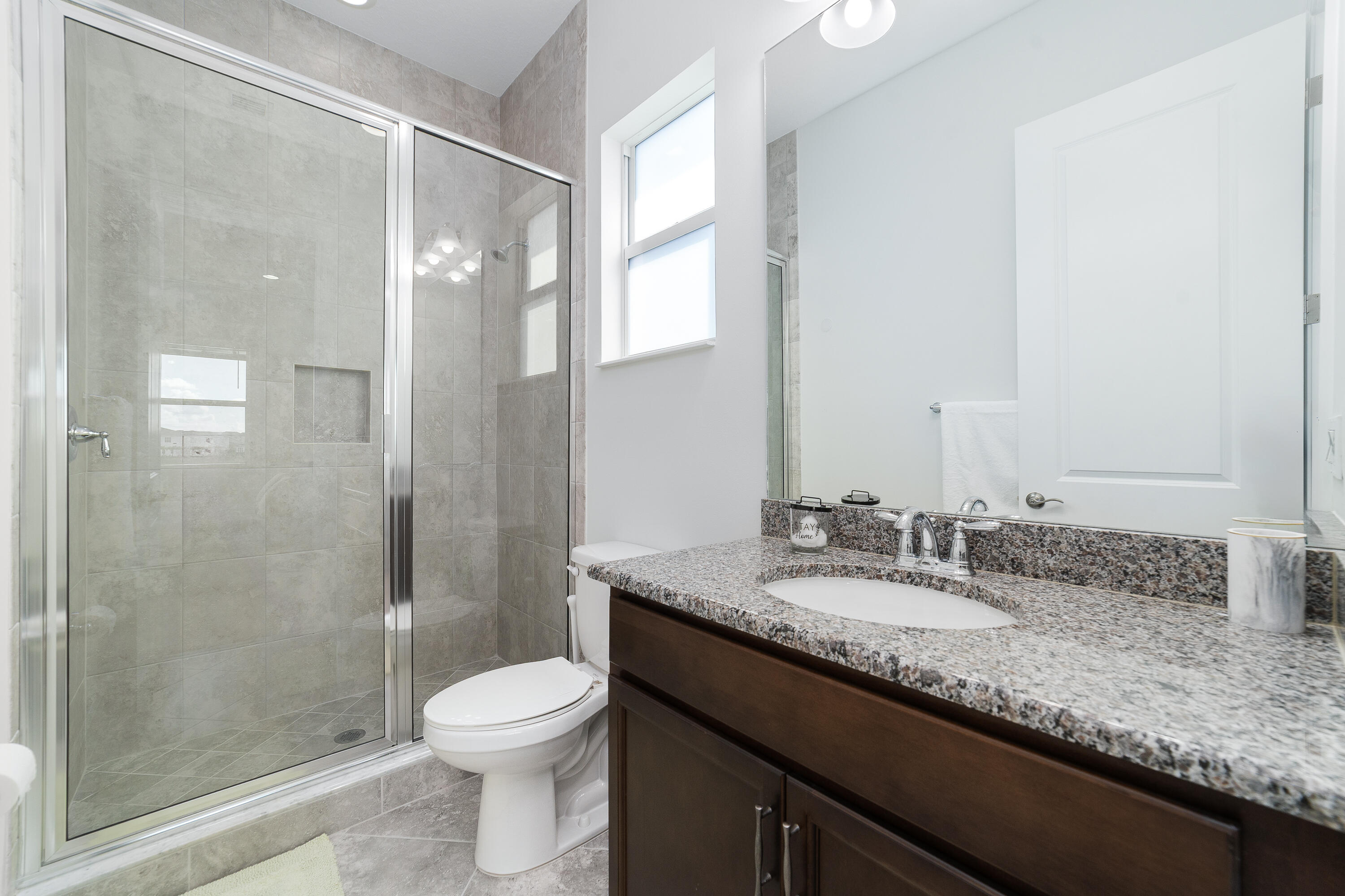 5487 Macoon Way Loxahatchee, FL 33470 - Photo 37 of 66 a bathroom with a granite countertop sink toilet a large mirror and shower