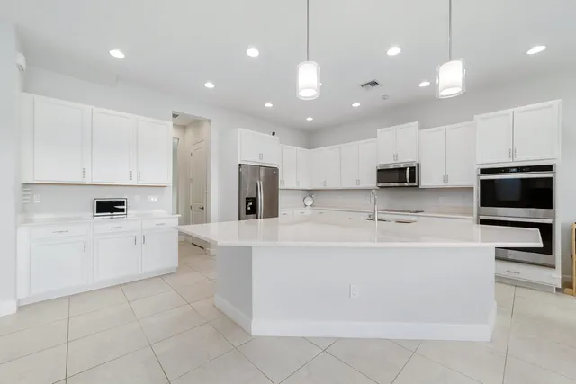 a kitchen with stainless steel appliances granite countertop white cabinets a sink and a stove