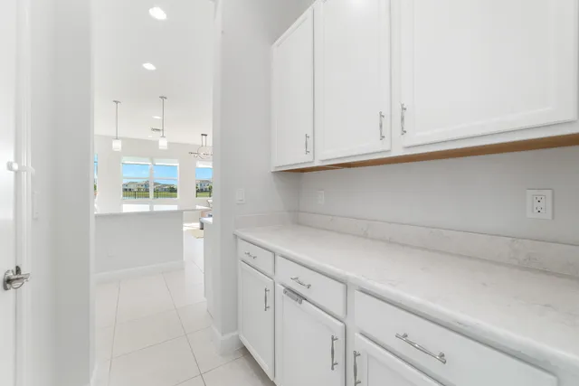 a large white kitchen with stainless steel appliances granite countertop a stove and white cabinets
