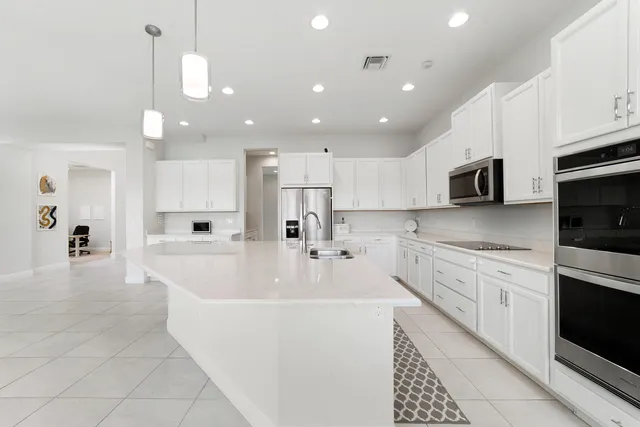 a dining room with kitchen island furniture a large window and stainless steel appliances