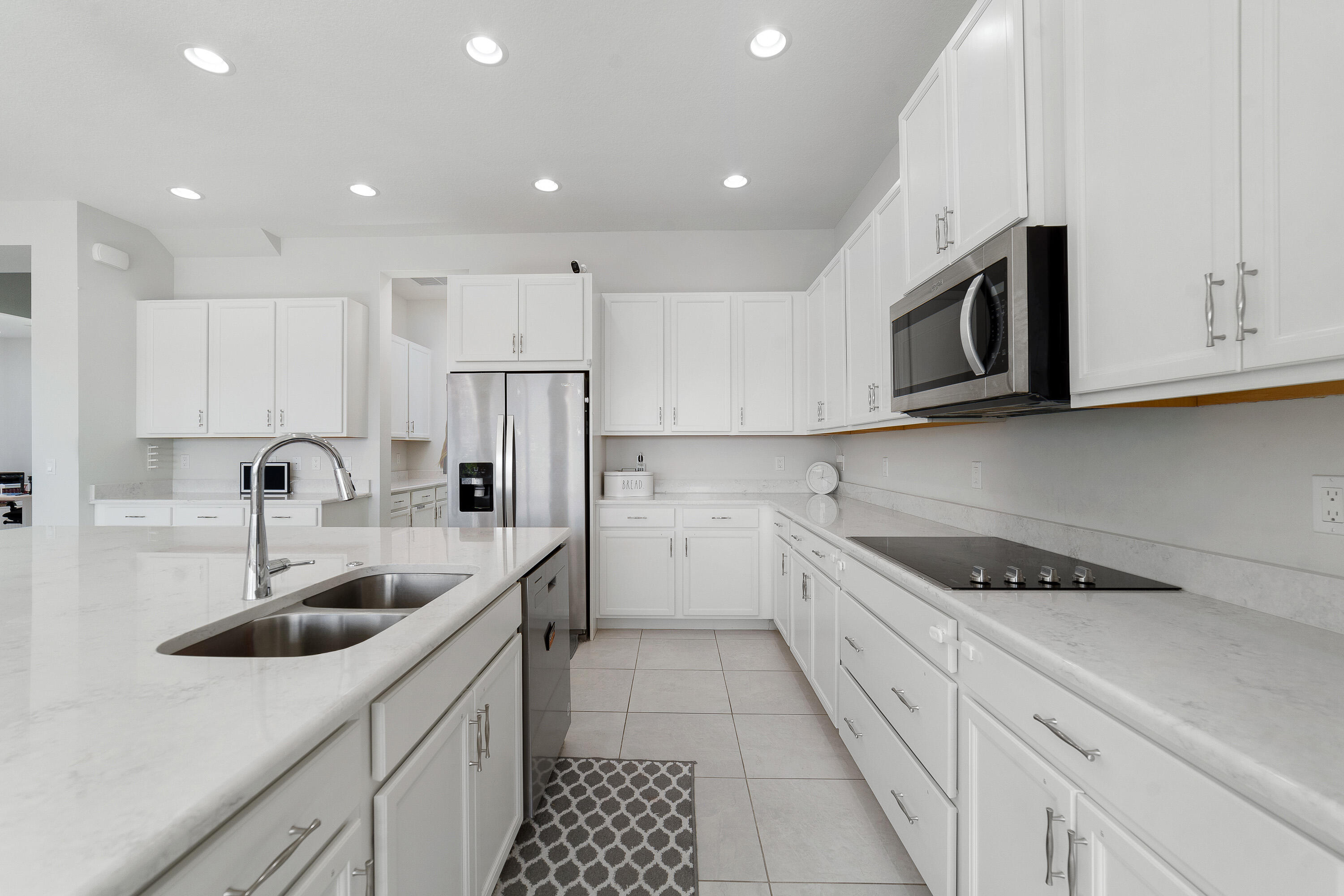 5487 Macoon Way Loxahatchee, FL 33470 - Photo 10 of 66 a kitchen with stainless steel appliances granite countertop white cabinets a sink and a stove