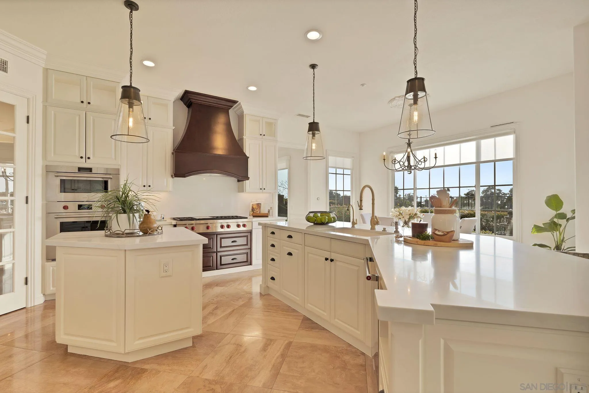 698 Cypress Hills Drive Encinitas, CA 92024 - Photo 21 of 44 a kitchen with stainless steel appliances kitchen island granite countertop a stove a sink a refrigerator and white cabinets with wooden floor