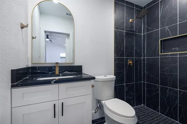 a bathroom with a toilet sink and mirror