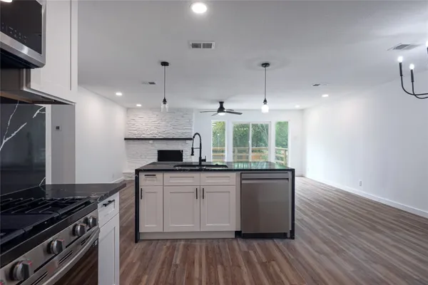 a kitchen with granite countertop a stove and a wooden floors
