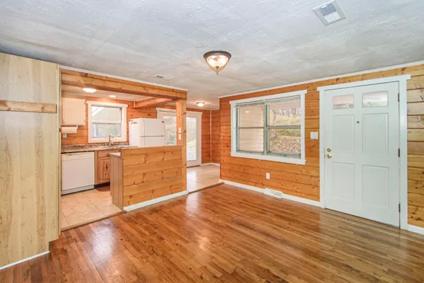 a view of a kitchen with wooden floor and a refrigerator