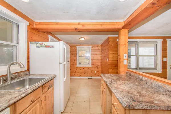 a bathroom with a granite countertop sink and a large mirror