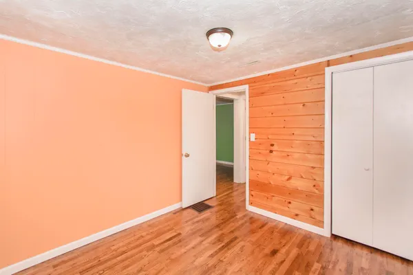 an empty room with wooden floor and door