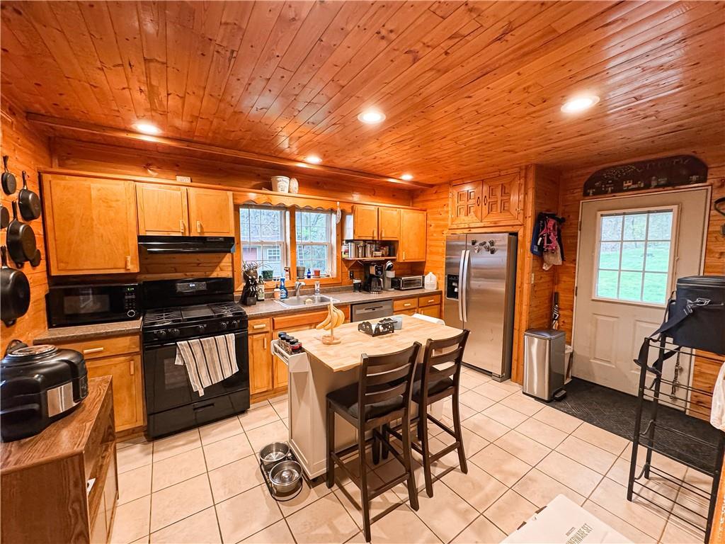 125 McGrew Road Clairton, PA 15025 - Photo 15 of 25 a kitchen with stainless steel appliances granite countertop a stove a refrigerator a sink a dining table and chairs with the view of living room