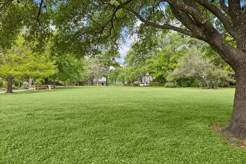 a view of green field with trees in the background