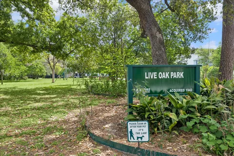 a sign that is sitting in front of a tree