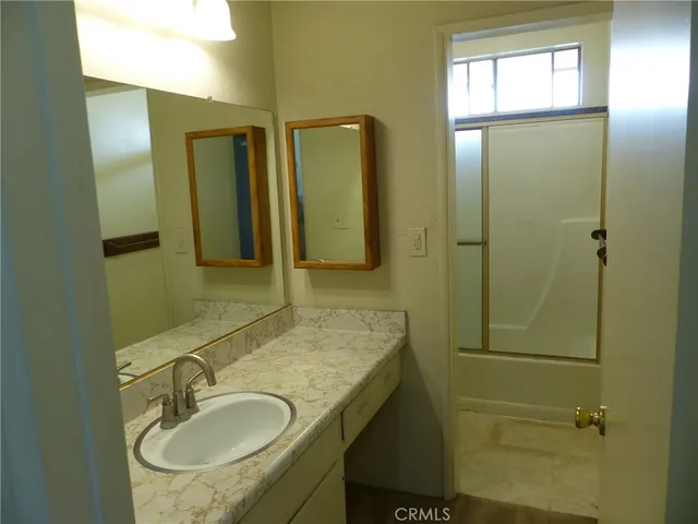 a bathroom with a sink a mirror and shower