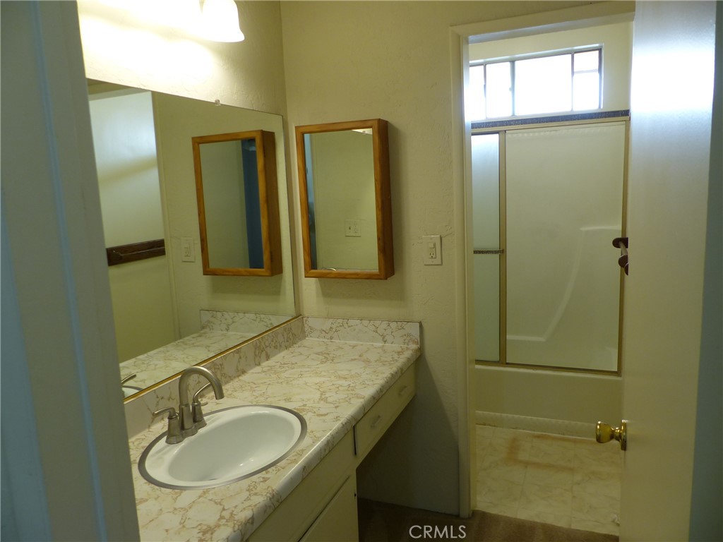 10708 Walnut Street Los Alamitos, CA 90720 - Photo 8 of 13 a bathroom with a sink a mirror and shower