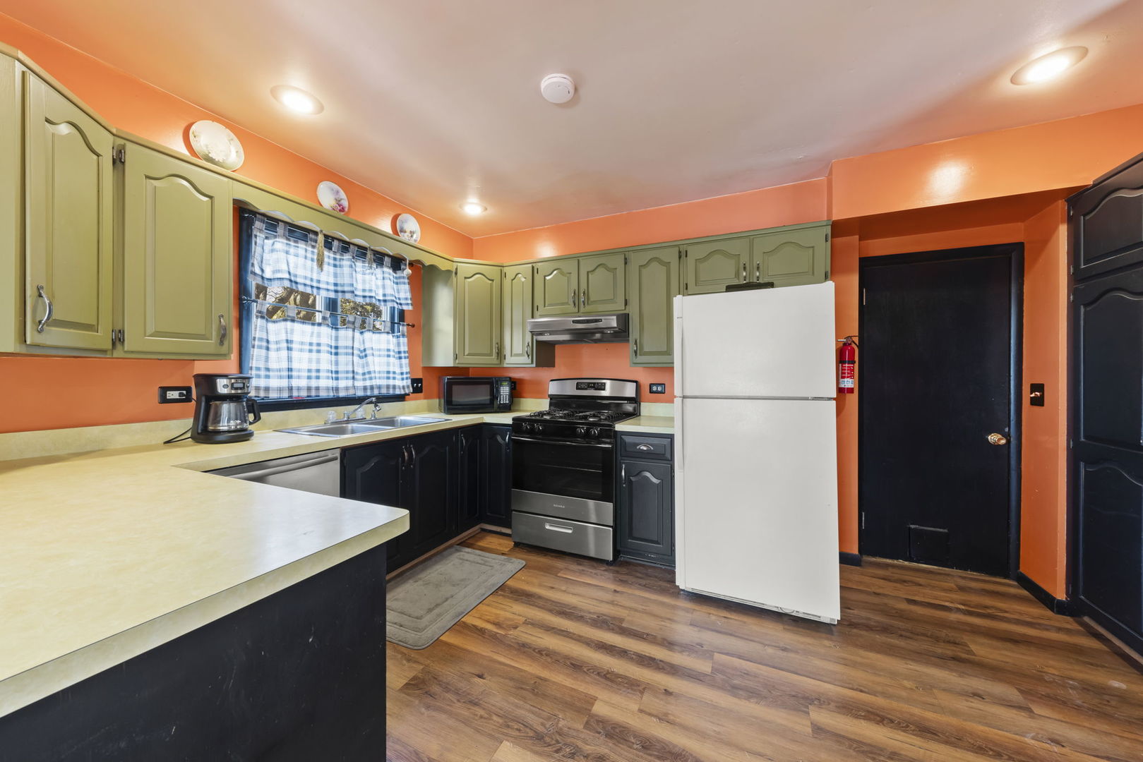 208 West Locust Street DeKalb, IL 60115 - Photo 9 of 26 a kitchen with granite countertop a refrigerator and a stove top oven