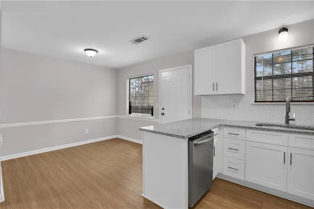 a kitchen with granite countertop white cabinets and white appliances
