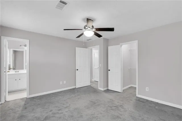 a view of an empty room and chandelier fan