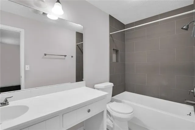 a bathroom with a sink a toilet and a mirror