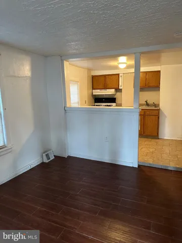 a view of empty room with wooden floor and windows
