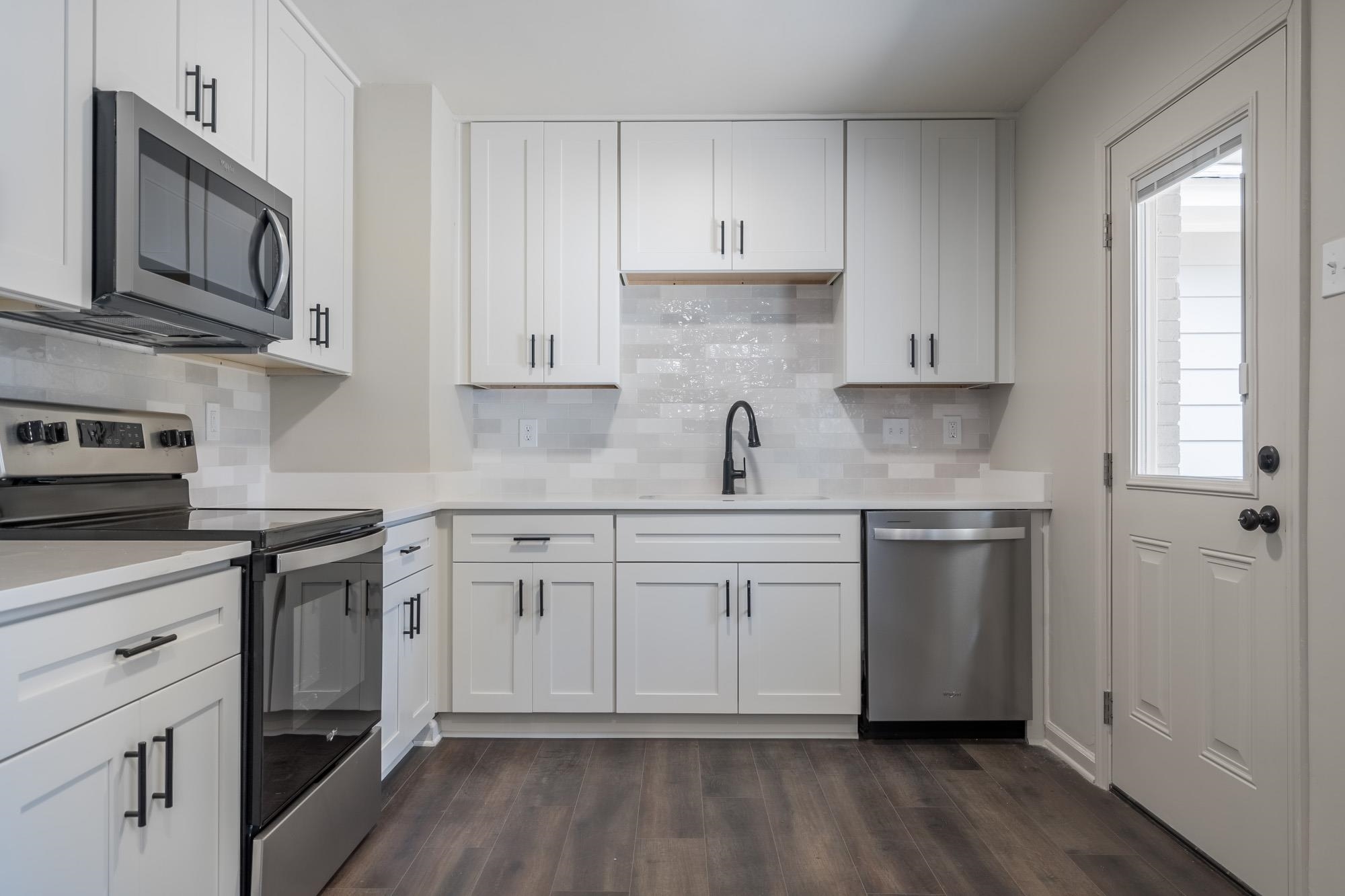 1014 Wellsville Road Memphis, TN 38117 - Photo 11 of 25 a kitchen with stainless steel appliances granite countertop white cabinets granite counter tops and a hard wood floors