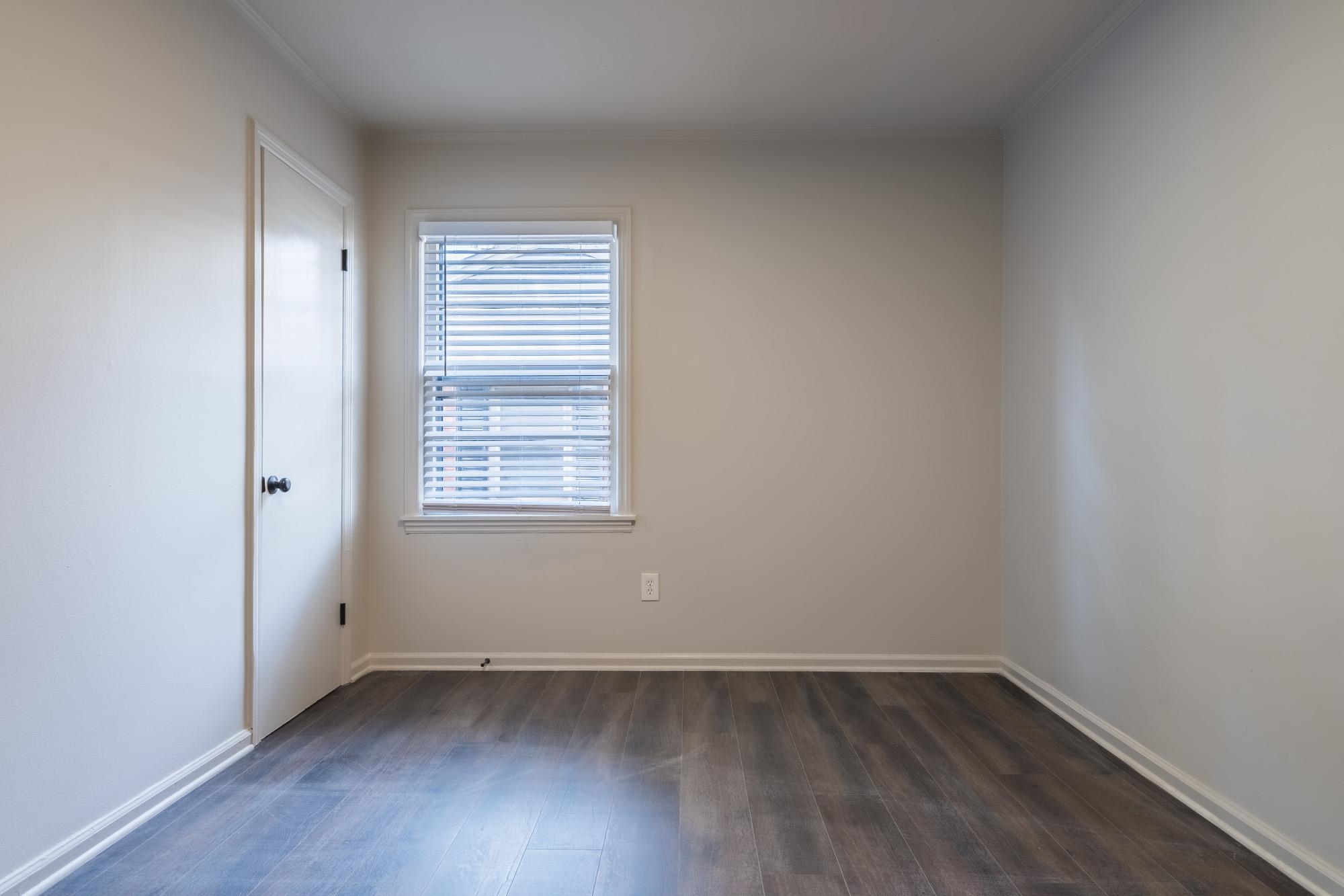 1014 Wellsville Road Memphis, TN 38117 - Photo 12 of 25 a view of an empty room with wooden floor and a window