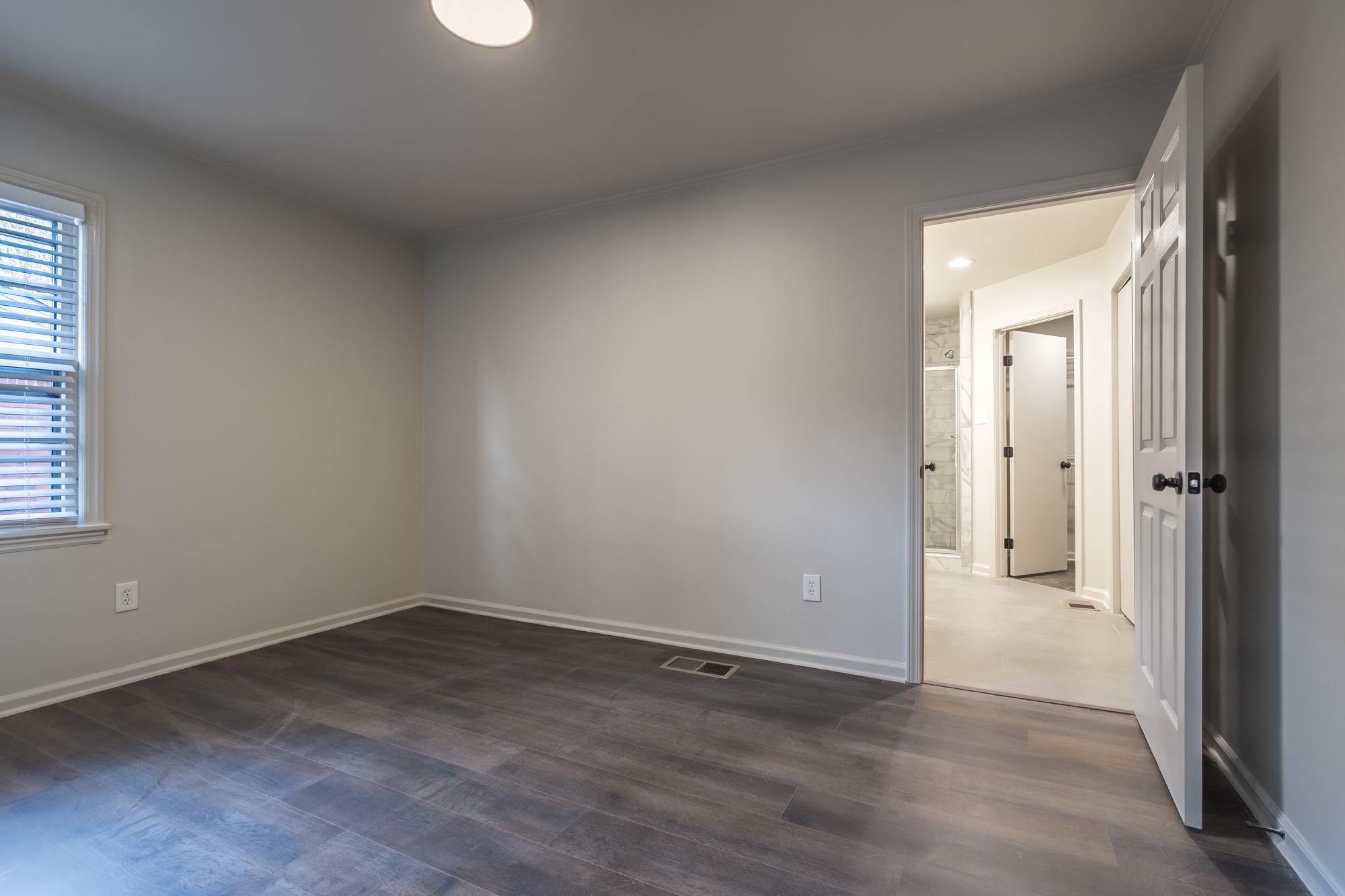 1014 Wellsville Road Memphis, TN 38117 - Photo 14 of 25 an empty room with wooden floor and windows