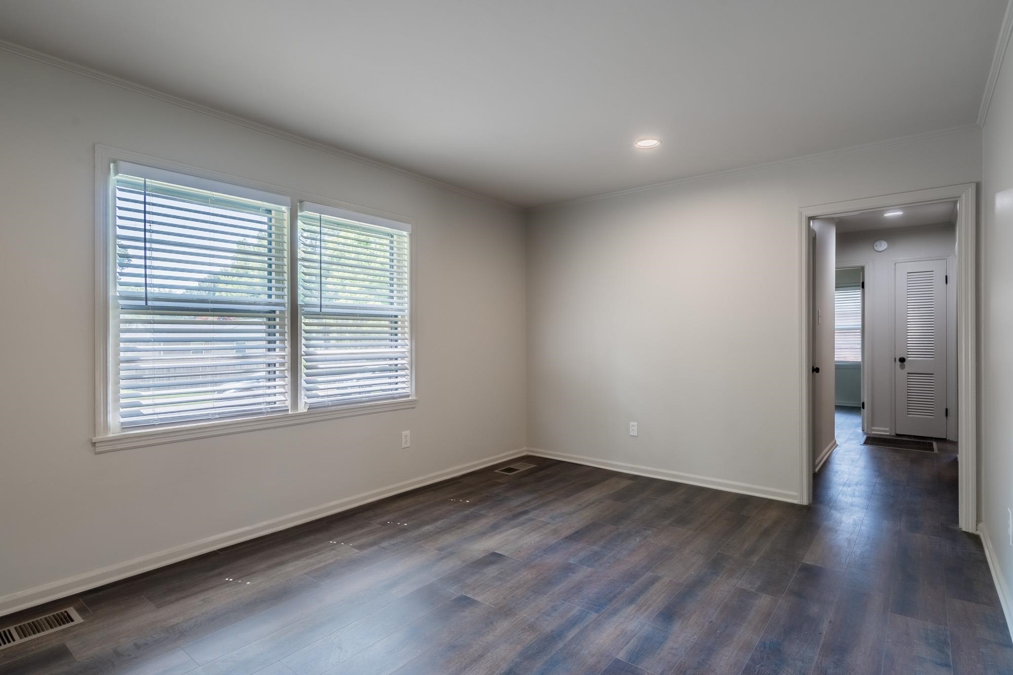 1014 Wellsville Road Memphis, TN 38117 - Photo 4 of 25 a view of an empty room with wooden floor and a window