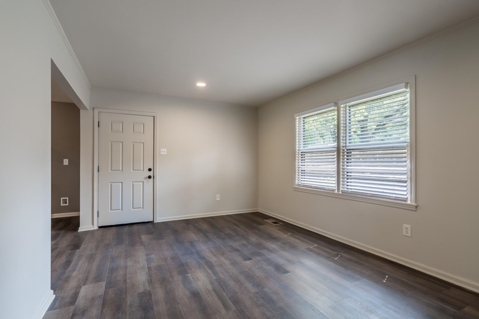 1014 Wellsville Road Memphis, TN 38117 - Photo 5 of 25 an empty room with wooden floor and windows