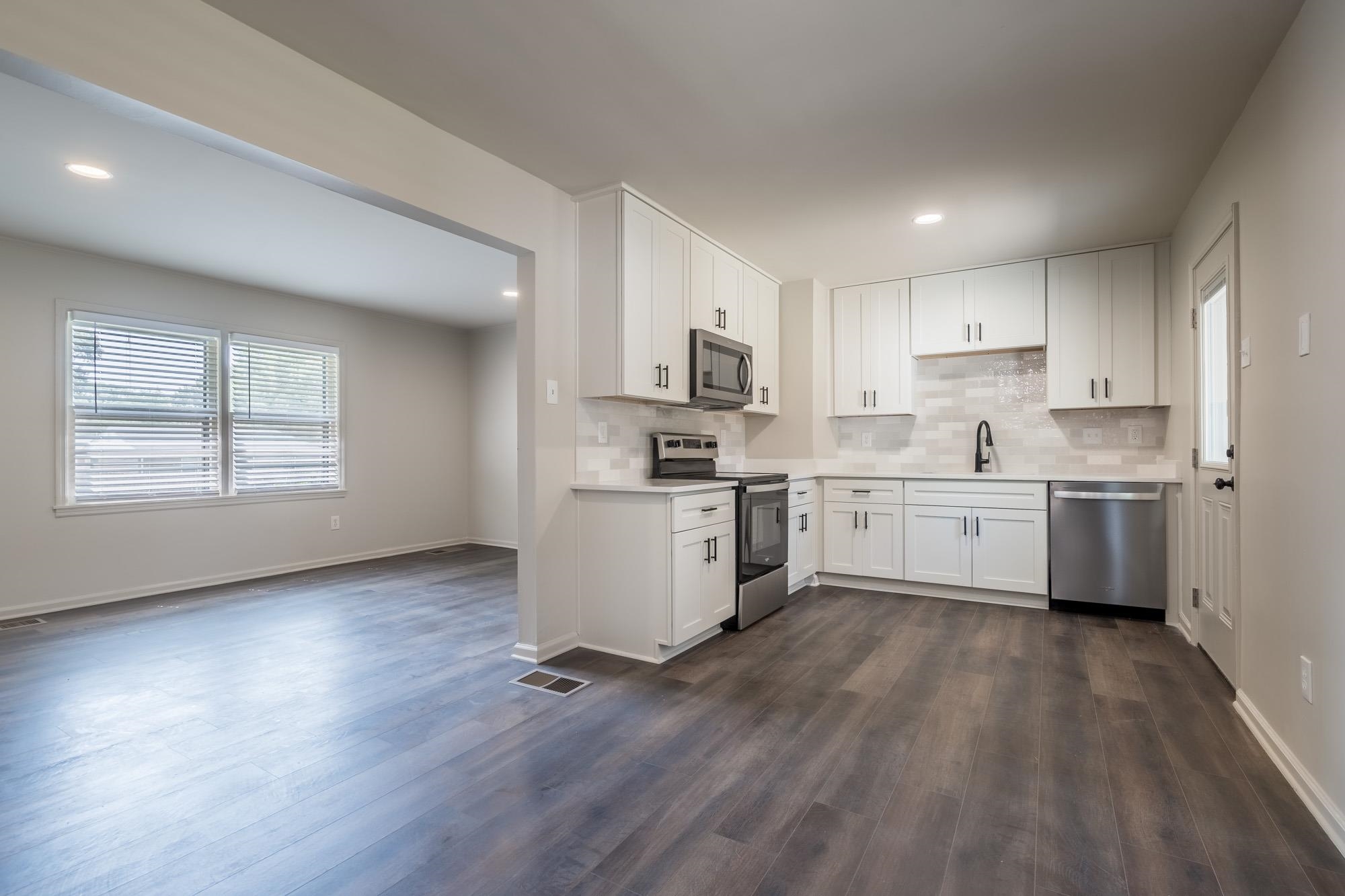 1014 Wellsville Road Memphis, TN 38117 - Photo 10 of 25 a kitchen with wooden floors a sink stainless steel appliances and cabinets