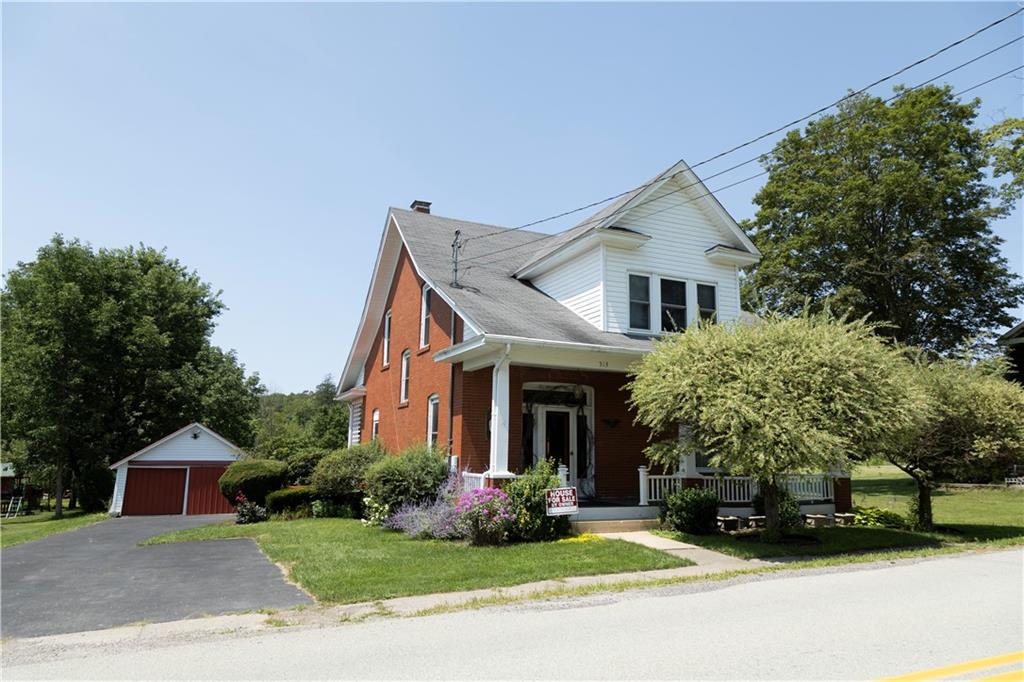 a front view of a house with a garden and plants
