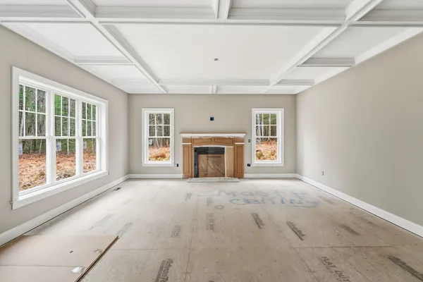 a view of an empty room with a fireplace and a window