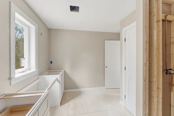 a view of an empty room with window and cabinet