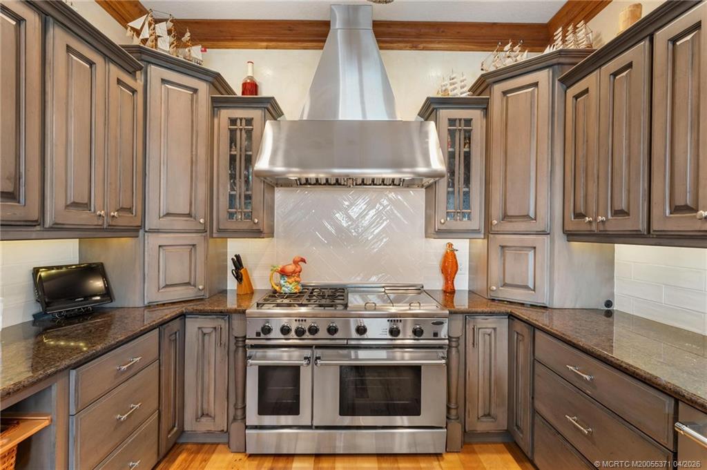5675 Southeast Orange Street Stuart, FL 34997 - Photo 15 of 96 a kitchen with stainless steel appliances granite countertop a stove and a refrigerator