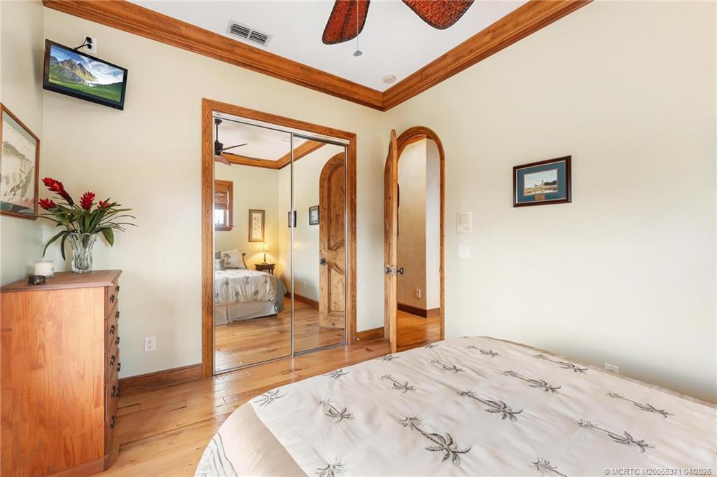 5675 Southeast Orange Street Stuart, FL 34997 - Photo 22 of 96 a bedroom with a bed and a chandelier