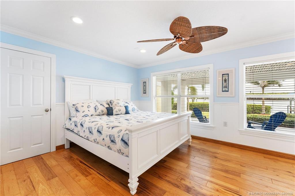 5675 Southeast Orange Street Stuart, FL 34997 - Photo 29 of 96 a bedroom with a bed and a large window with wooden floor