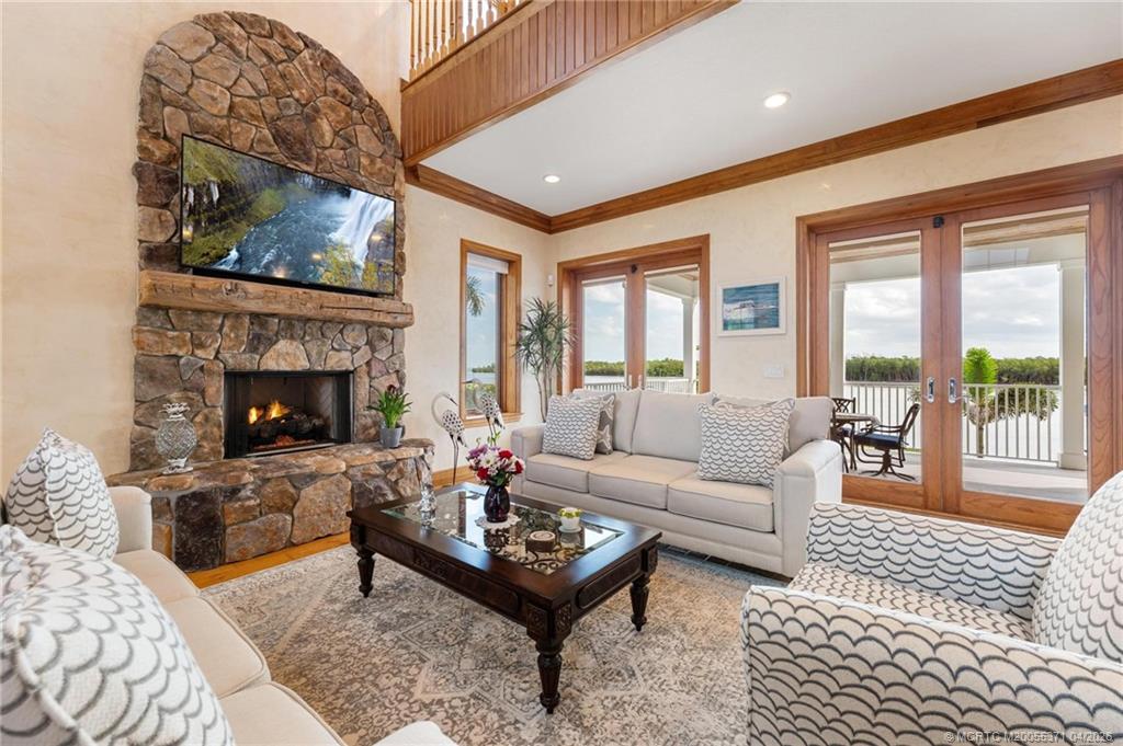 5675 Southeast Orange Street Stuart, FL 34997 - Photo 6 of 96 a living room with furniture and a fireplace