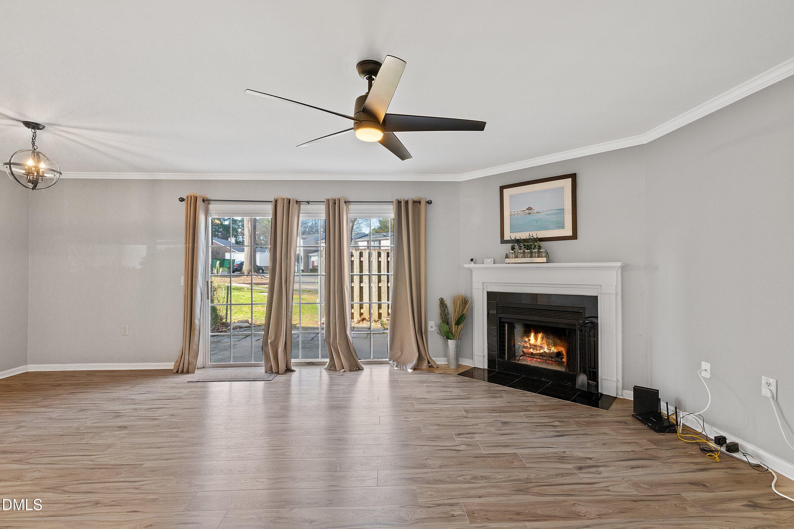 2400 Condor Court Raleigh, NC 27615 - Photo 22 of 40 a view of an empty room with wooden floor fireplace and a window