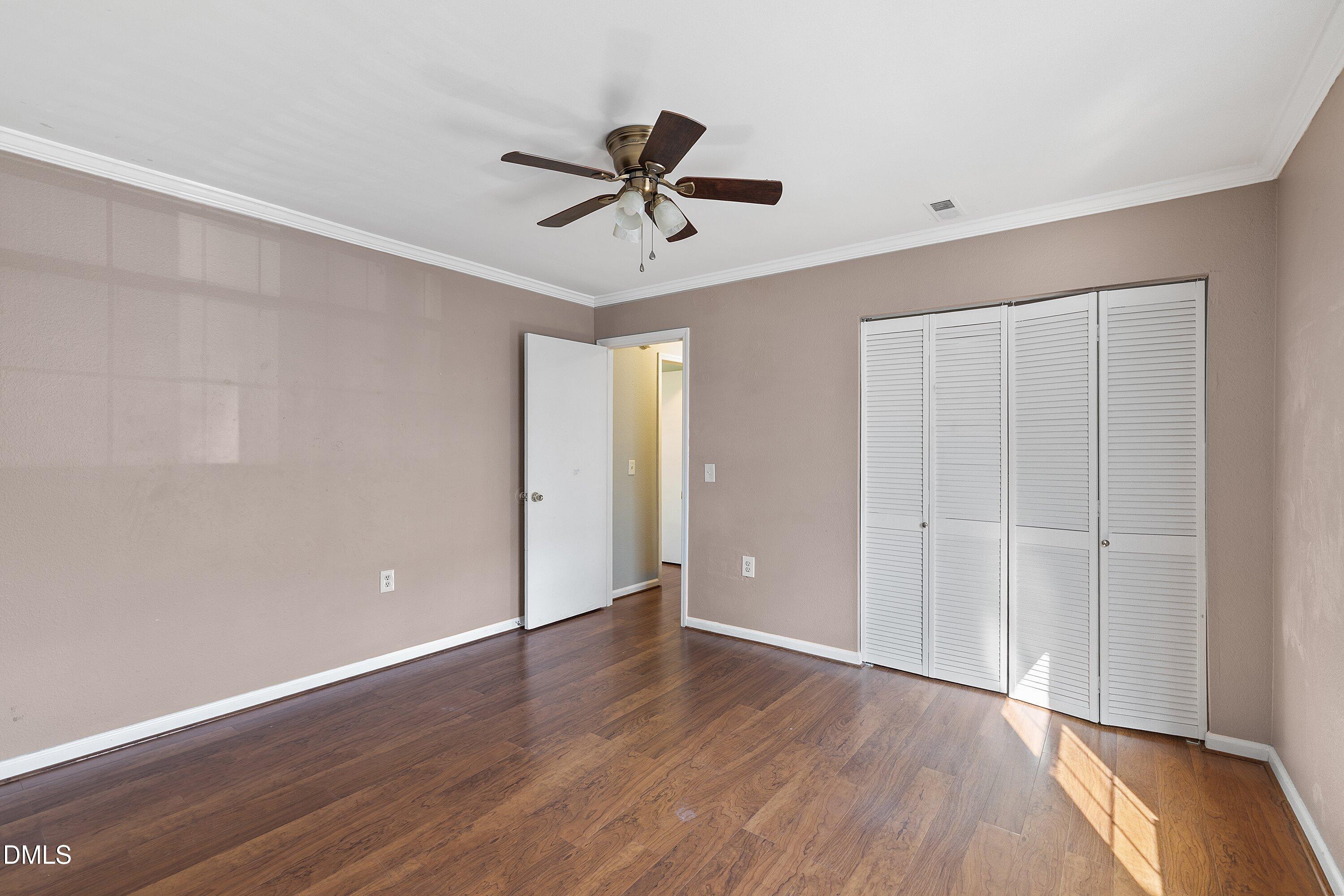 2400 Condor Court Raleigh, NC 27615 - Photo 32 of 40 a view of an empty room with wooden floor and a ceiling fan