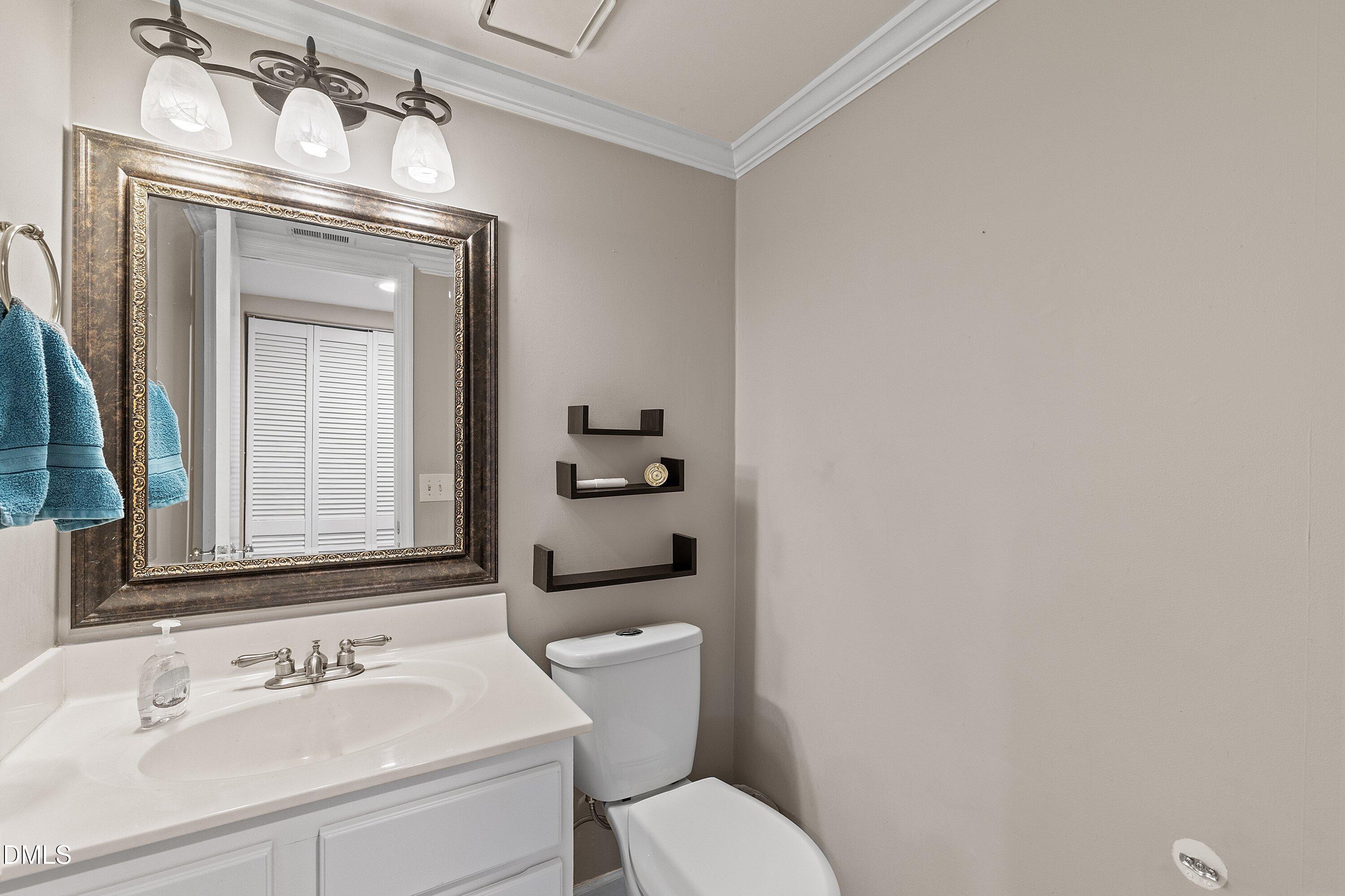 2400 Condor Court Raleigh, NC 27615 - Photo 7 of 40 a bathroom with a toilet sink vanity and mirror